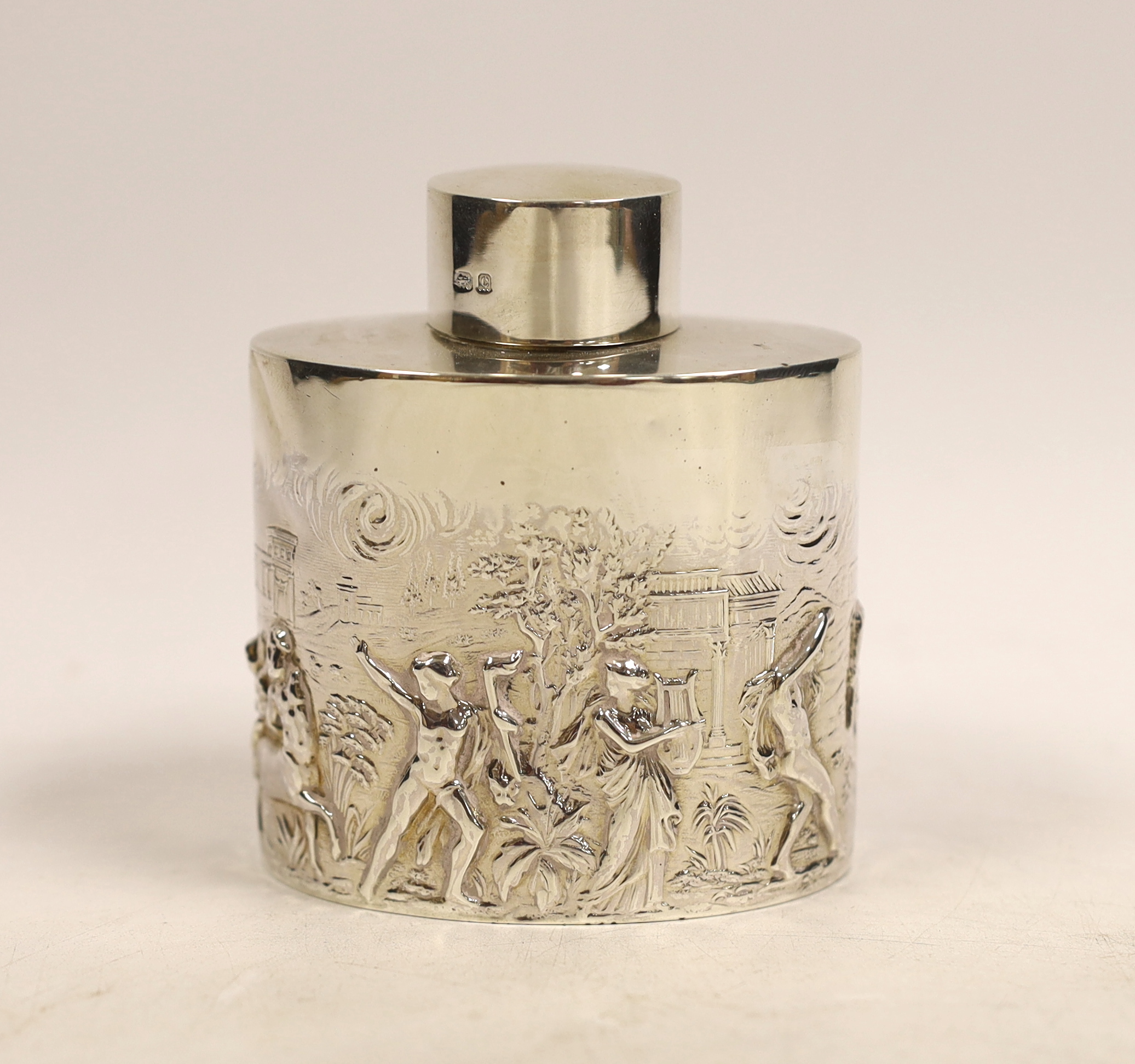 An Edwardian oval silver tea caddy embossed with all round Classical Greek imagery of figures, Parthenon and buildings, Nathan & Hayes, Birmingham, 1902, 90mm.